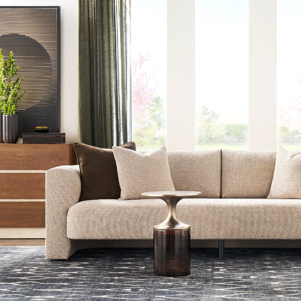 Luxurious transitional sofa with bench seationg and cushion back shown with round metal accent table.
