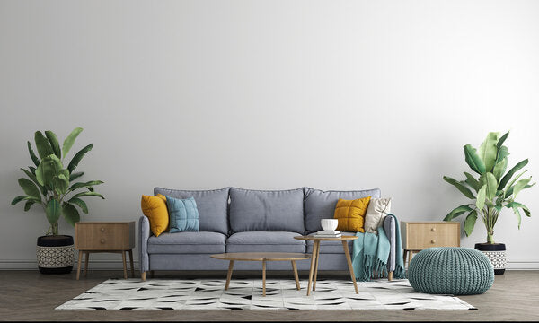  Scandinavian living room with grey sofa, mustard yellow and teal throw pillows, wooden side tables, tropical plants, and patterned area rug.