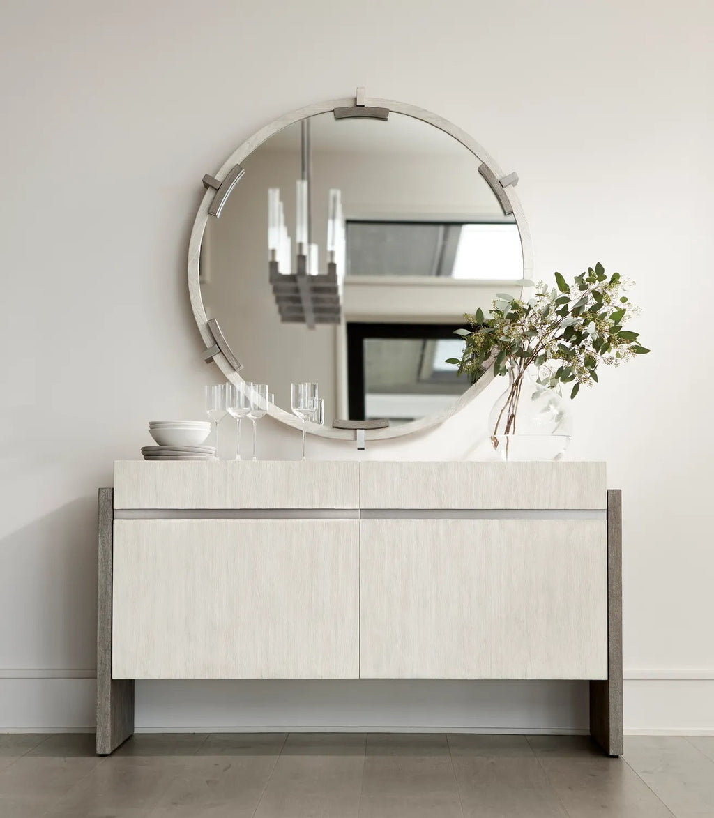 White oak two-door sideboard buffet with segmented round wall mirror and grey wood frame in minimalist dining room