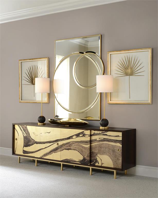 Luxury entryway vignette with gold marbled lacquer sideboard, double-ring brass mirror, paired table lamps, and botanical palm leaf wall art