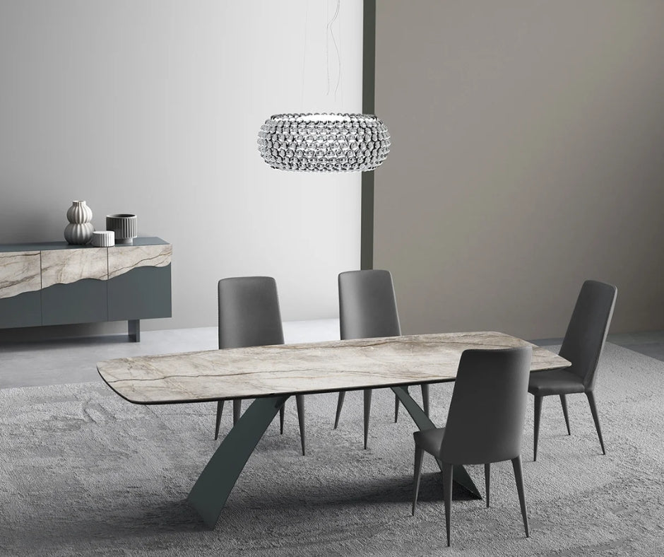 Marble-top dining table with sculptural green base and grey upholstered chairs.