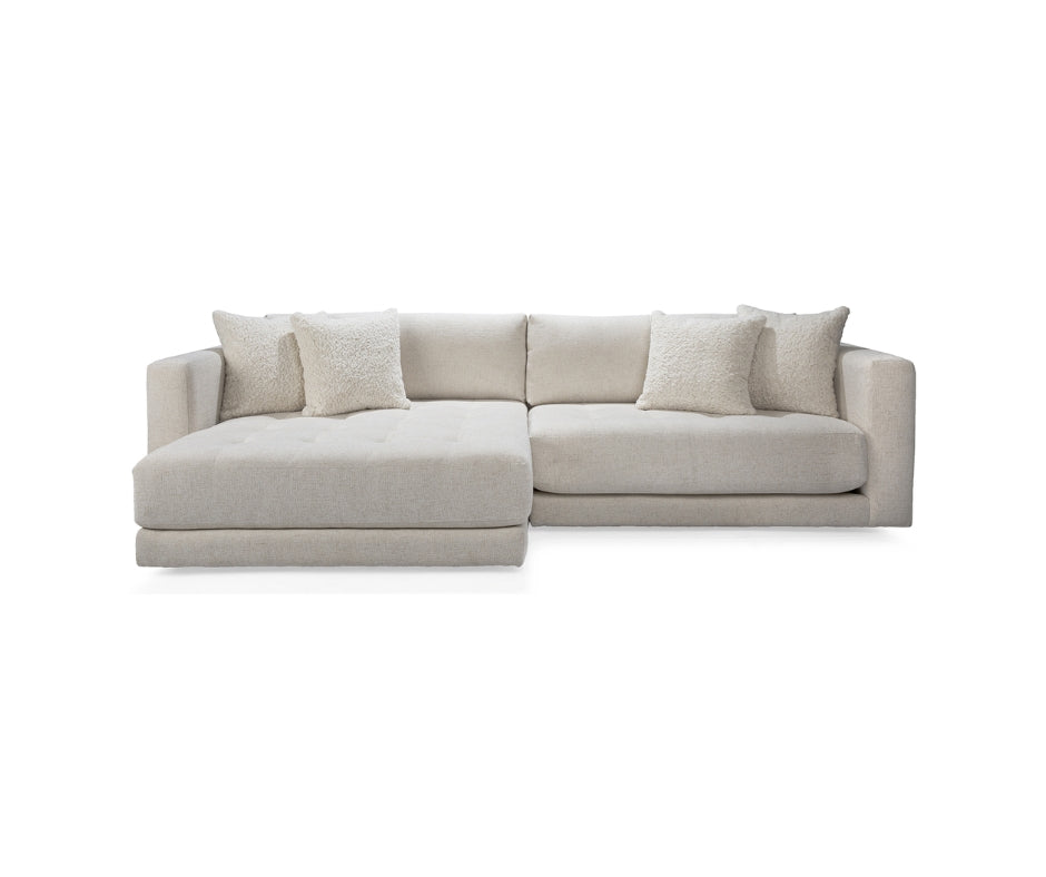 Ivory tufted sectional sofa with left-facing chaise and shearling accent pillows.