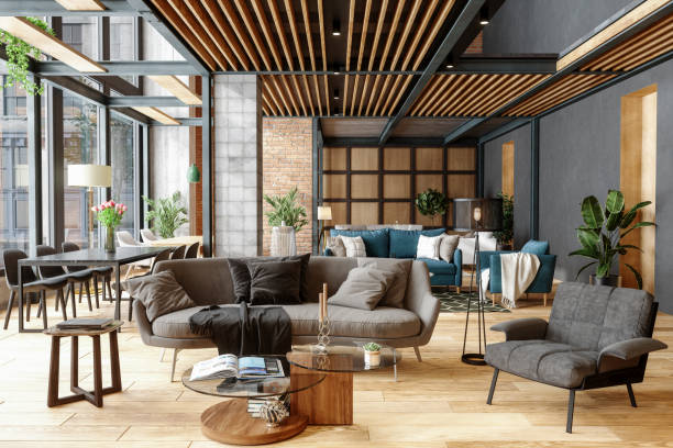  Industrial loft living room with grey modular sofa, glass coffee table, wood slat ceiling, and teal accent sofa in open-concept space.