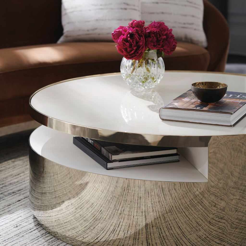 Modern coffee table with a vase of flowers and books in a living room setting.