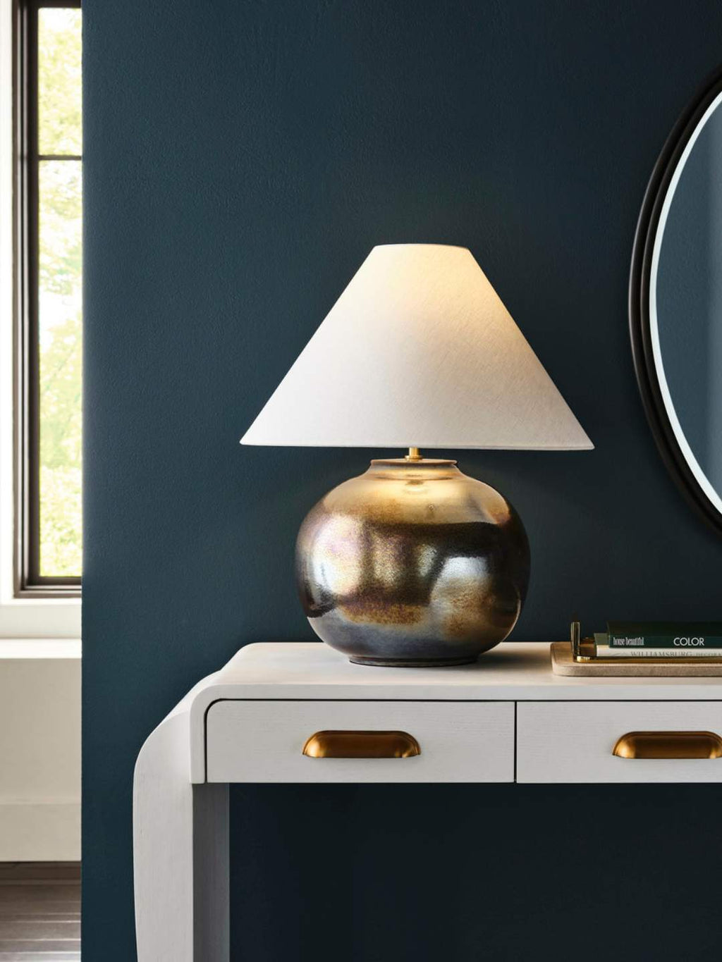 Art Deco inspired console with warm brass drawer pulls and hammered burnt metal lamp with oriental shped lamp shade.