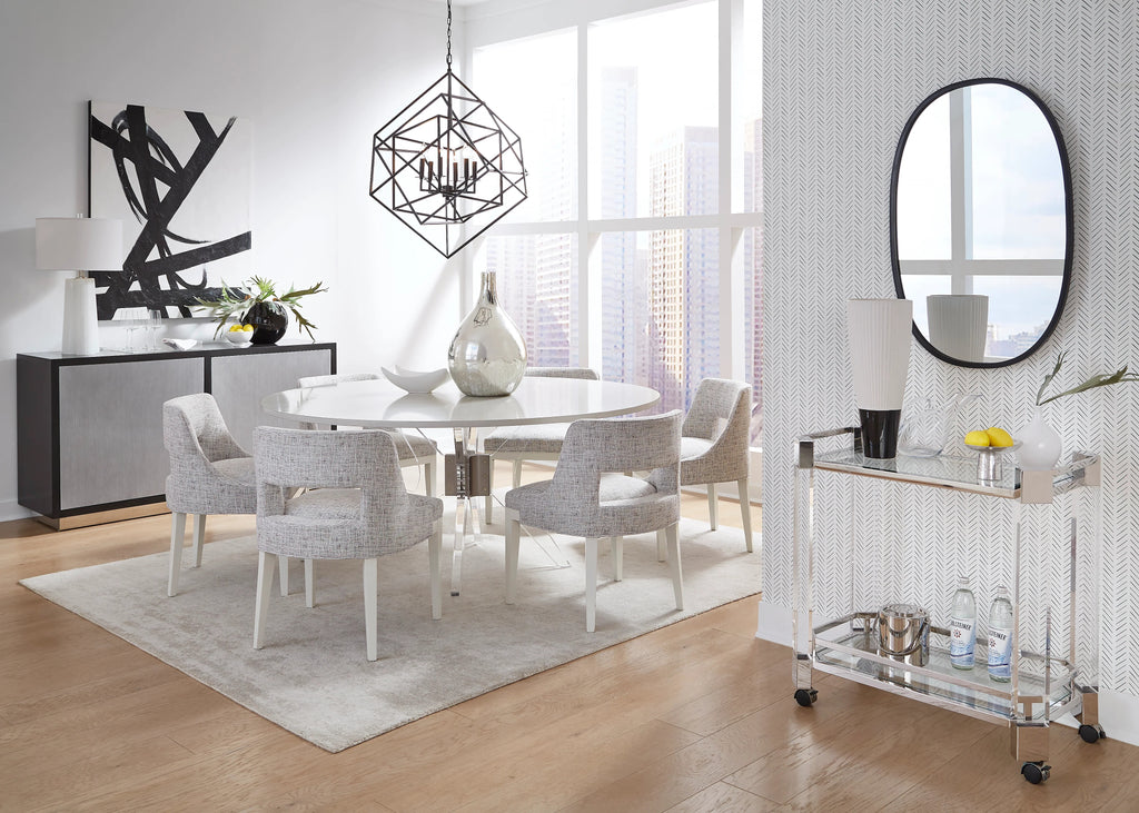 Table à manger ronde sur pied en laque blanche avec piètement en acrylique et chaises de salle à manger tapissées grises dans une salle à manger moderne en gratte-ciel avec chariot de bar