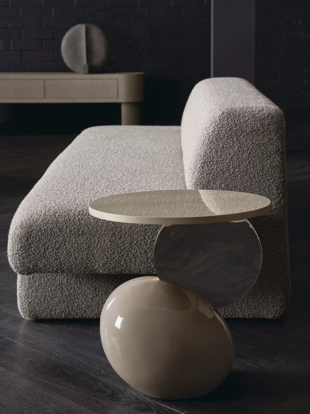 Modern gray sofa with a round side table in a dark room