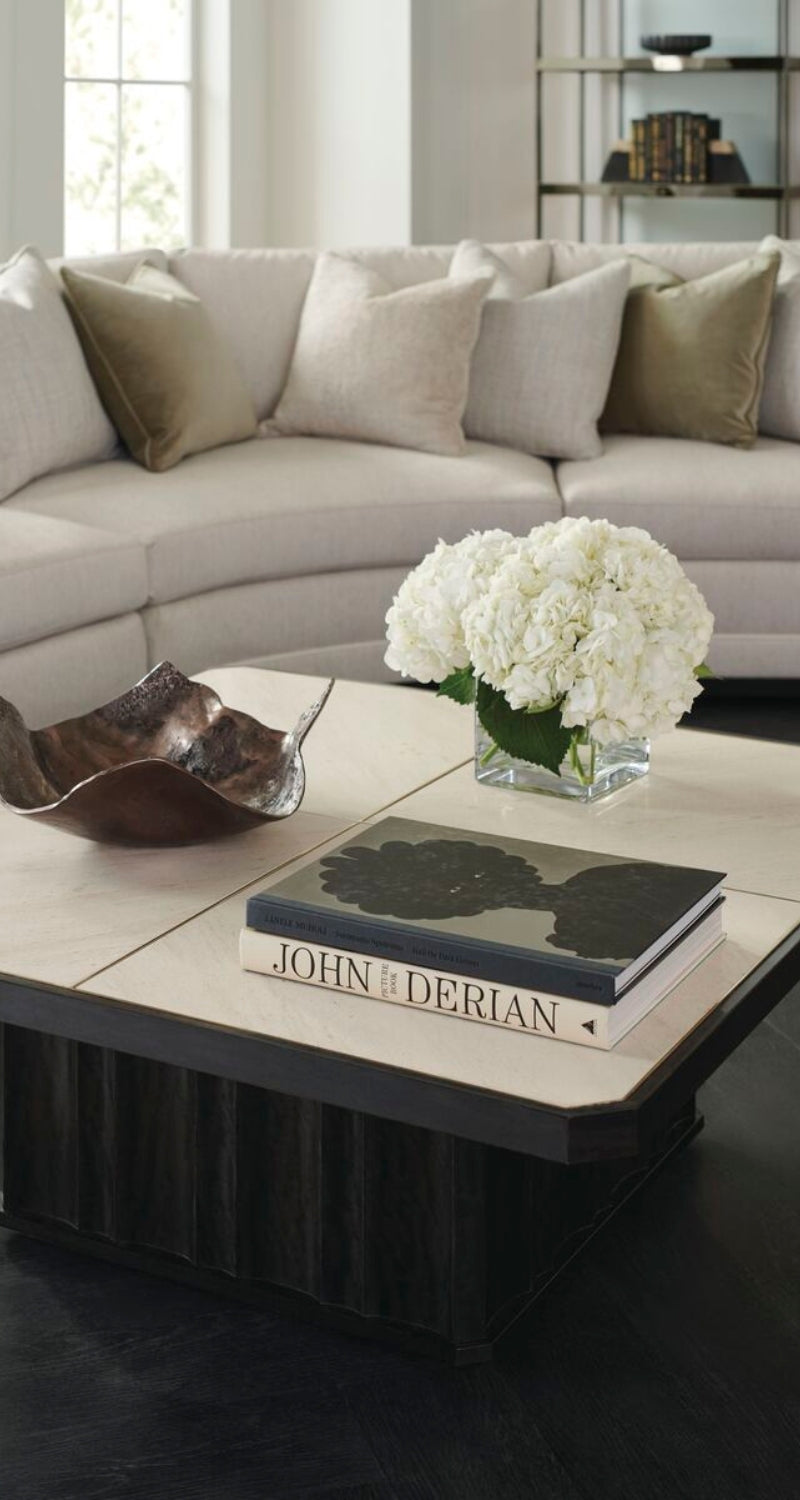 Modern living room with a sectional sofa, coffee table, and decorative items.