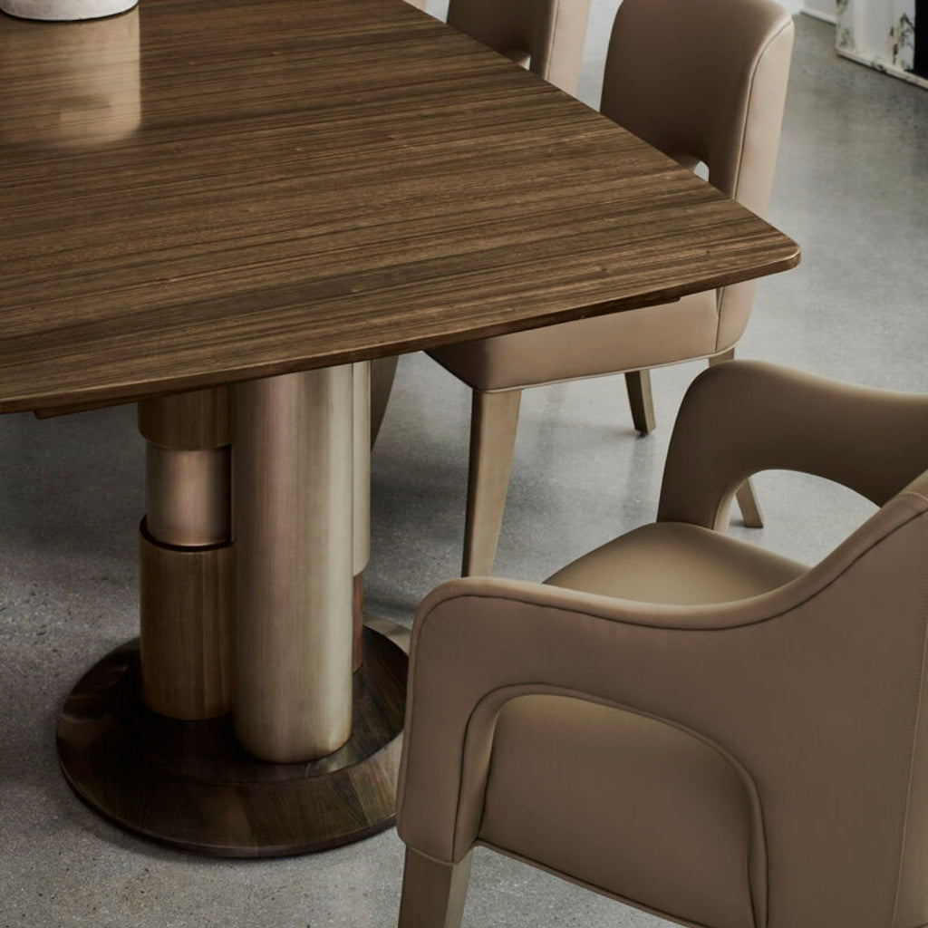 Dining table with bronze legs and chairs in a modern setting
