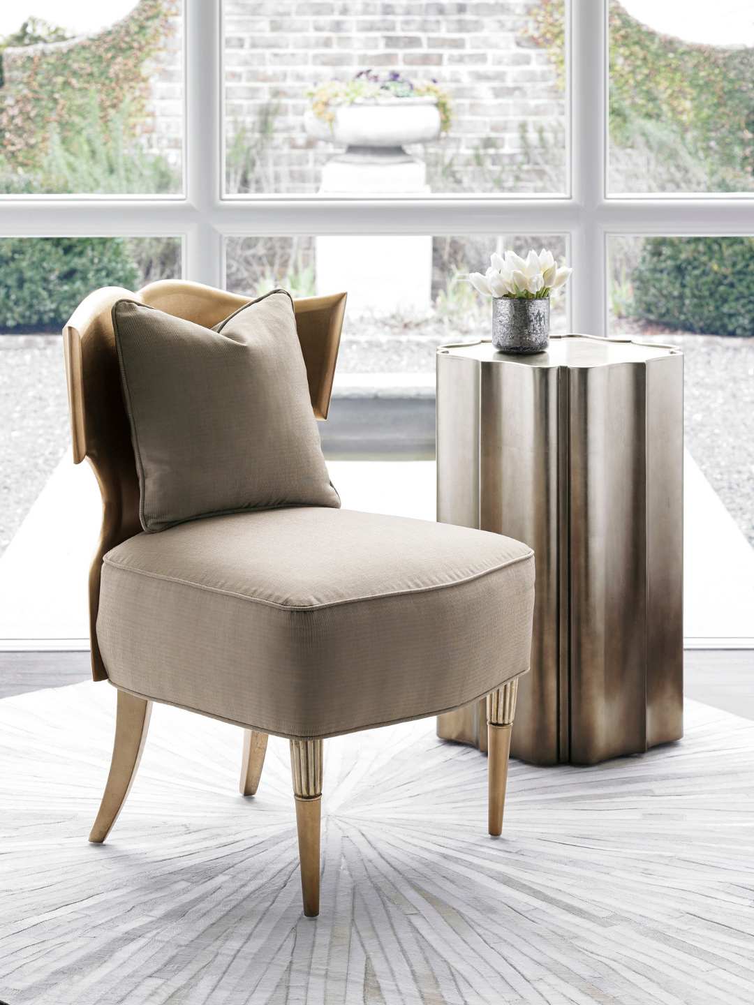 Beige armchair with a pillow in a room with large windows.