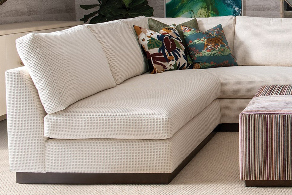 Beige sectional sofa with colorful pillows in a living room setting