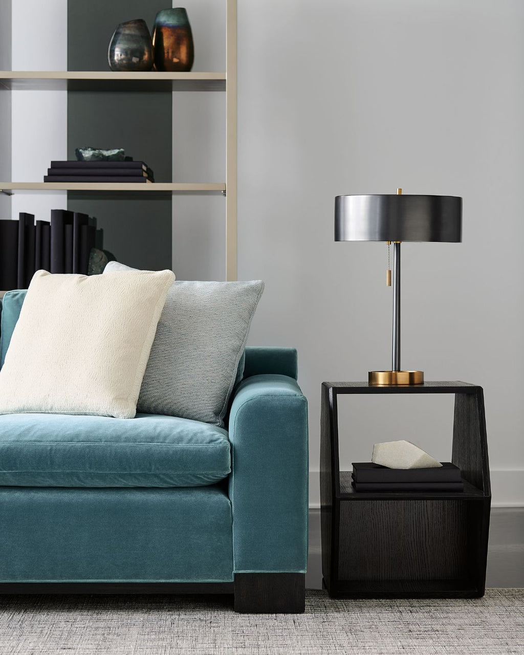 Modern living room with a blue sofa, side table, and lamp.