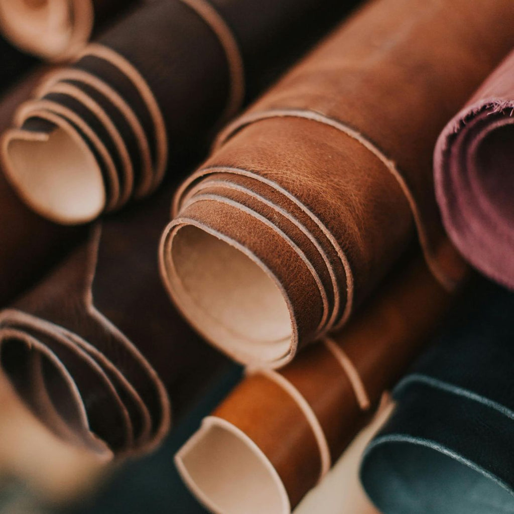 Close-up of various leather rolls in different colors.