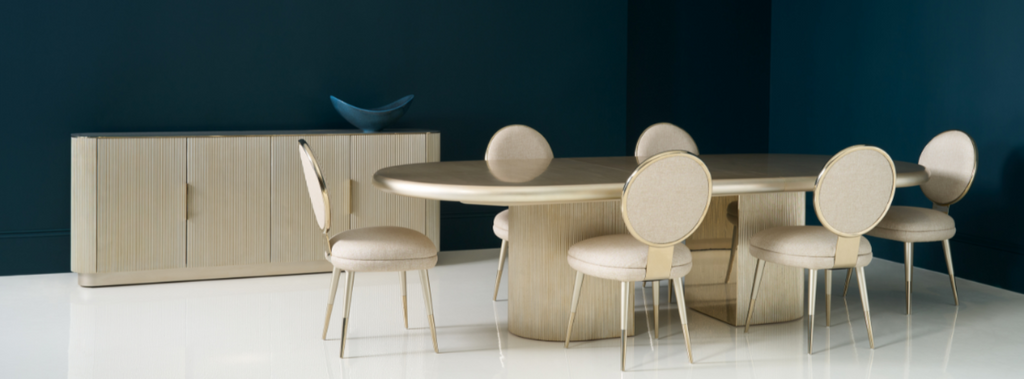 Dining room setup with a round table and chairs against a dark wall.