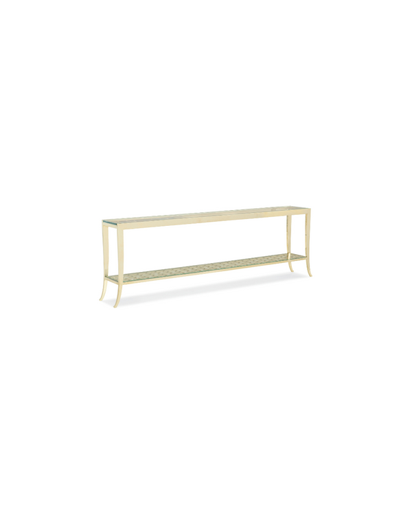 Long, narrow table with a light gold frame, clear glass top, and lower woven metal shelf, supported by slim legs with curves on a white background.
