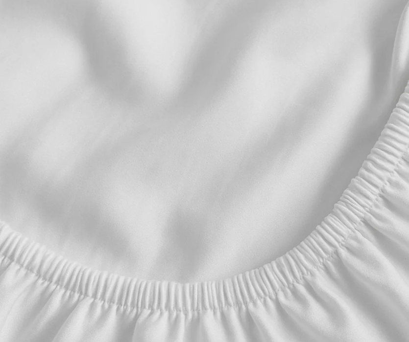 Pale, smooth material gathered in gentle folds with a subtle sheen, shown as a light, even upholstery surface in a neutral tone