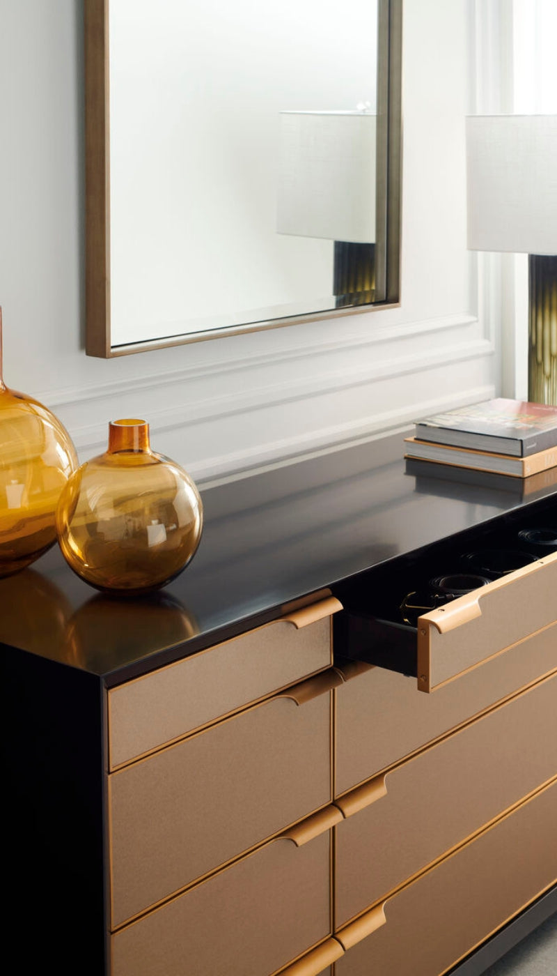 Modern dresser with gold accents and decorative items in a room.