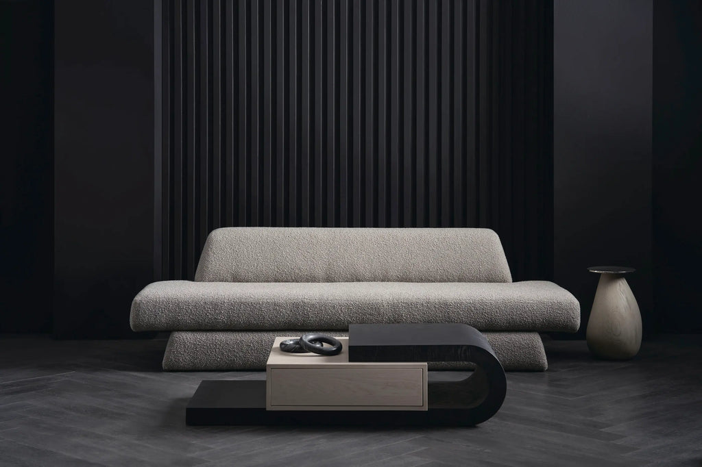 Beige boucle sofa with black and taupe curved coffee table in dark modern living room