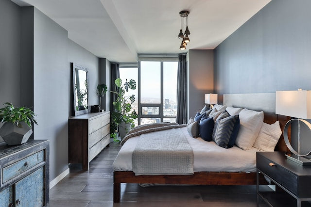 Wide view of a minimalist luxury bedroom with a low-profile king-size bed, white bedding, and clean architectural lines in a neutral interior