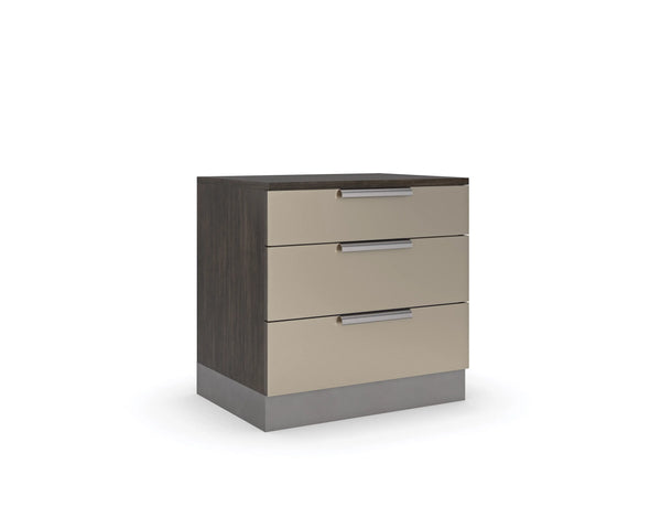 Modern bedside table with three beige drawers, slim metal handles, a dark wood frame, and a solid base, shown on a white background.