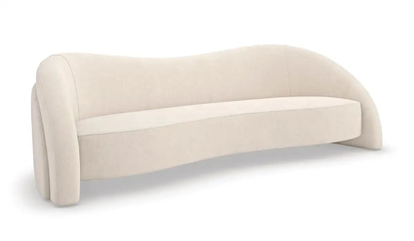 Cream-colored upholstered sofa with a curved silhouette, rounded arms, and a low-profile cushioned seat in a modern minimalist design.