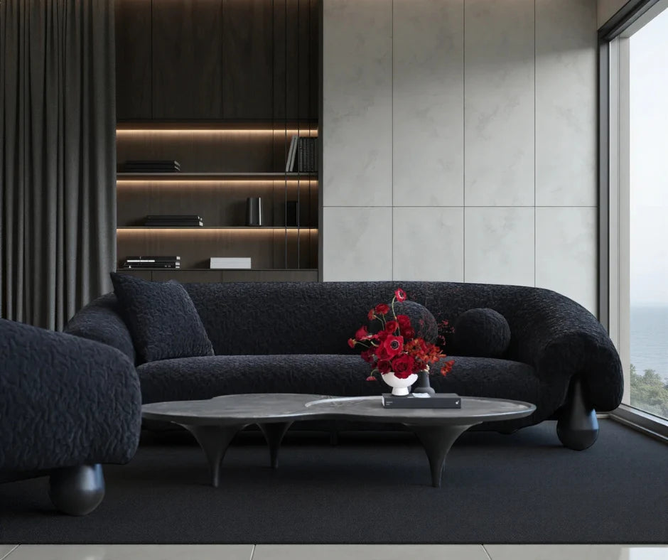 Black boucle curved sofa in modern living room with marble coffee table and floral centerpiece